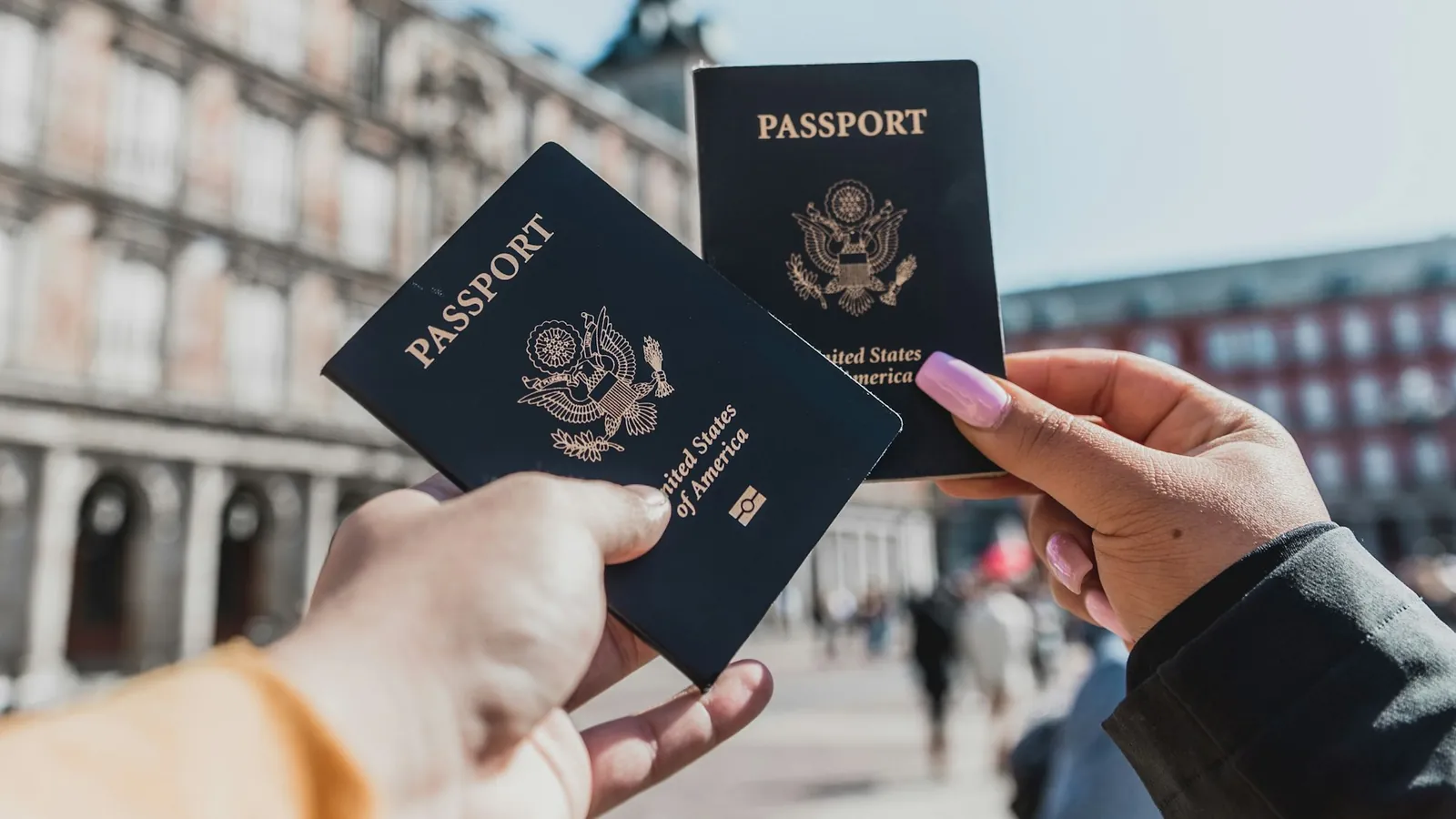 A passport and a work permit card on a desk, the advance parole document folded beside them